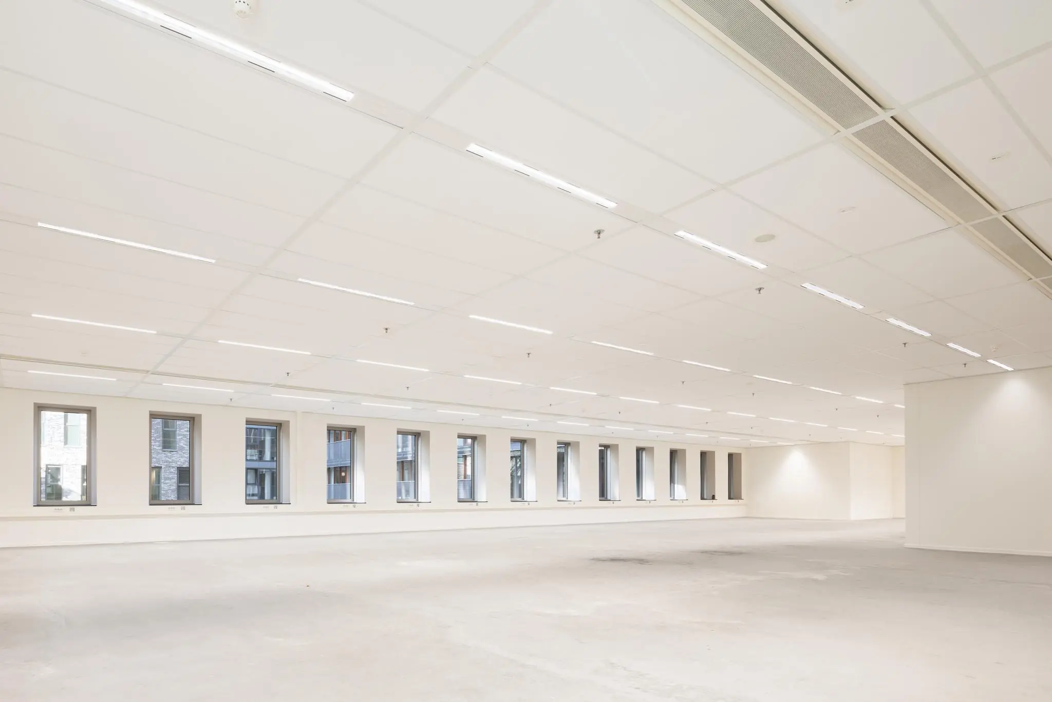 Leeg en licht kantoorruimte-interieur aan de Prinses Beatrixlaan met grote ramen en systeemplafond.